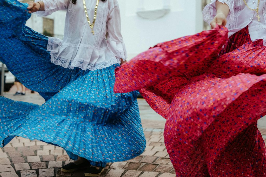 Danseuses de flamenco en tenue traditionnelle vibrant au rythme de la musique dans une rue animée pendant les Feria andalouses